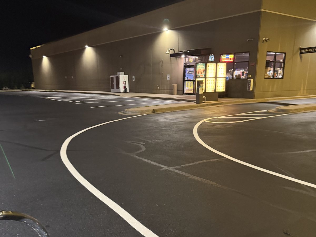 Fresh white drive lane line painted overnight at a gas station lot