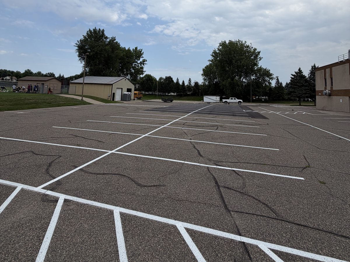 White stalls and ADA access aisle hatching restriped at a school parking lot in Rosemount, MN